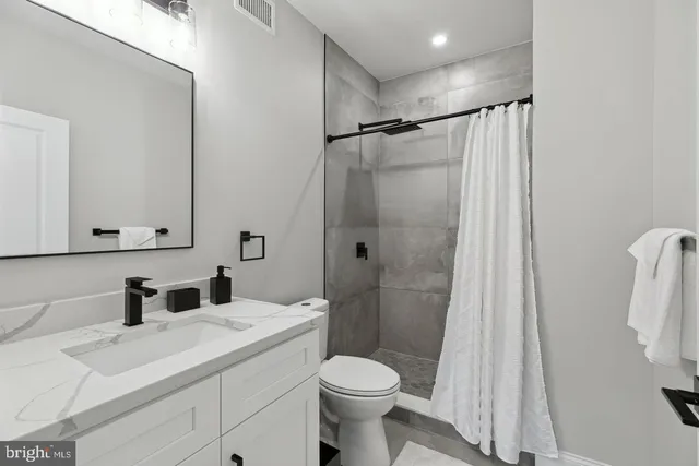 a bathroom with a sink toilet and shower