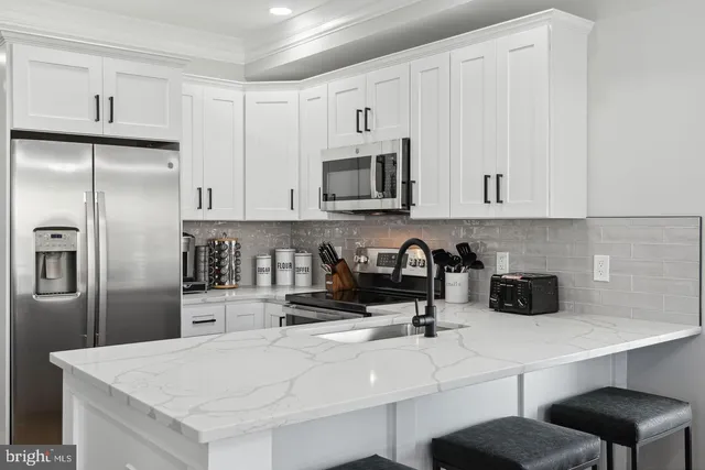 a kitchen with stainless steel appliances a refrigerator a sink a stove and cabinets