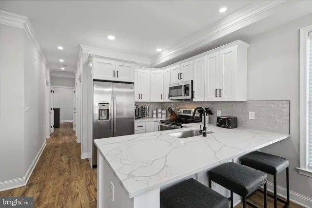 a kitchen with white cabinets and stainless steel appliances