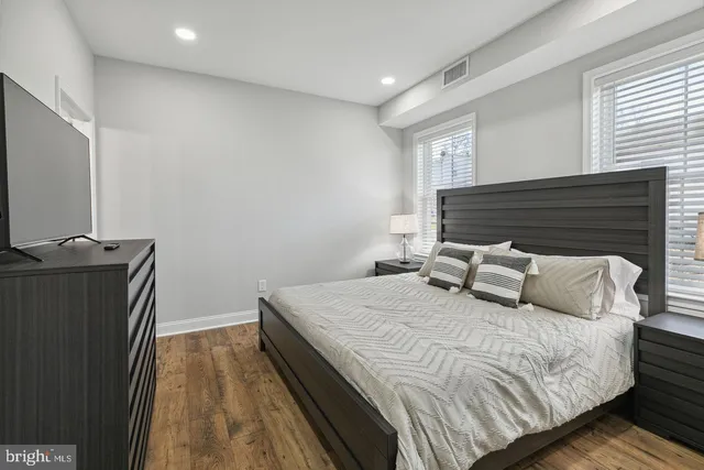 a bedroom with a bed and wooden floor