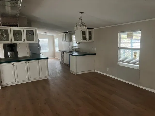 a kitchen with granite countertop a stove a sink and a microwave