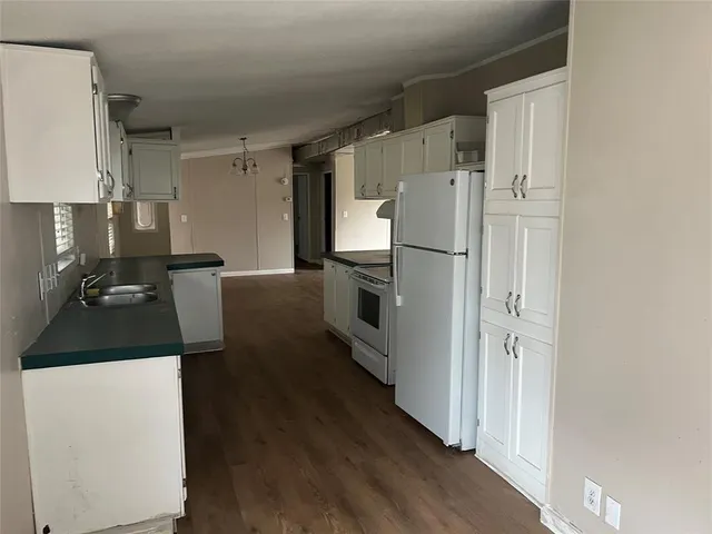 a kitchen with granite countertop a refrigerator and a stove top oven
