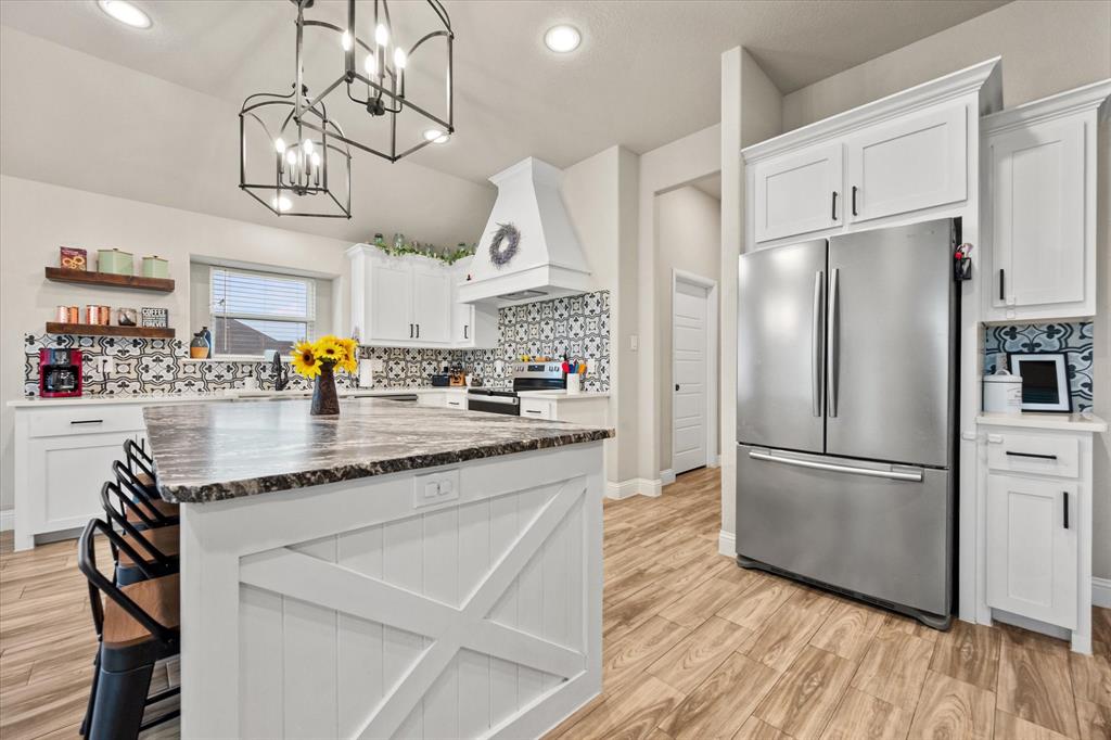 6365 Rhoden Avenue Godley, TX 76044 - Photo 10 of 31 a kitchen with stainless steel appliances granite countertop a refrigerator a oven a sink dishwasher and white cabinets with wooden floor