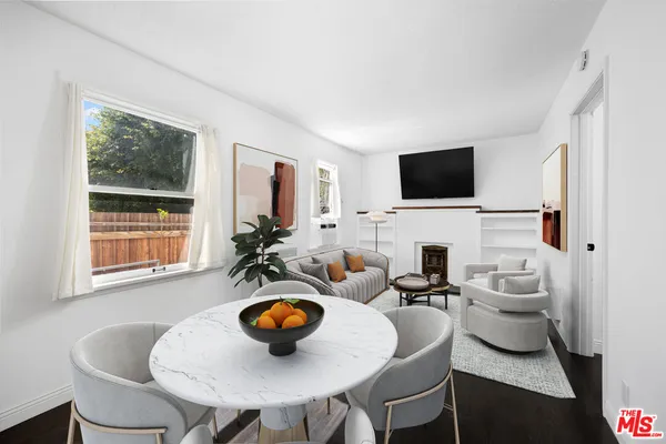 a living room with furniture a flat screen tv and a window