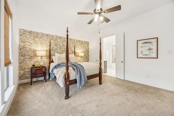 a bedroom with a bed large window and a table