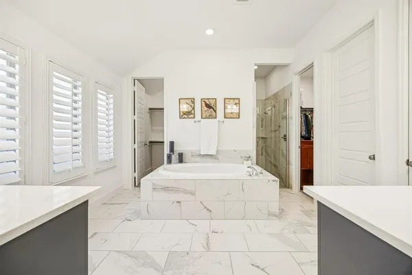 a spacious bedroom with a large bed and a large mirror