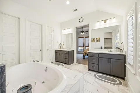 a bathroom with a tub sink and mirror