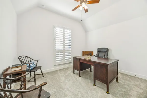 a view of a workspace with furniture and a window