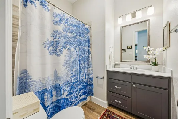 a bathroom with a granite countertop sink a toilet and a mirror