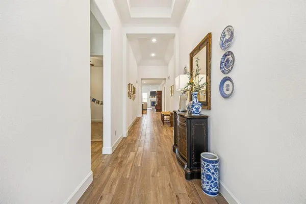 a view of a hallway with wooden floor and entryway