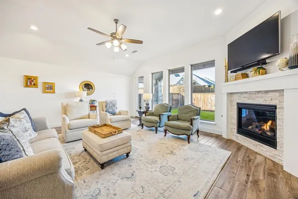 a living room with furniture a fireplace and a flat screen tv