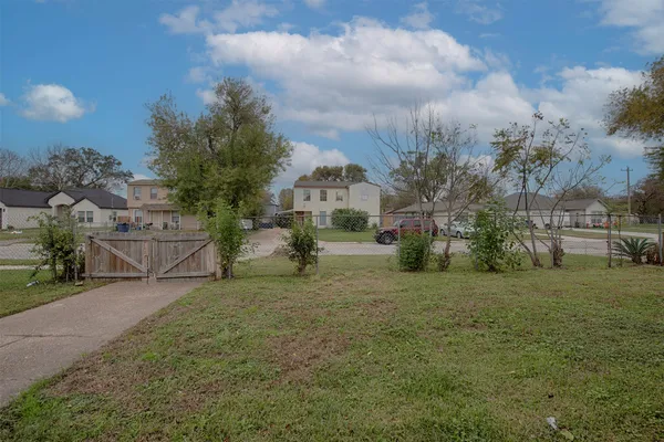 a view of a big house with a big yard and large trees