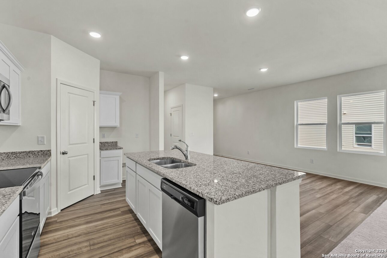 128 Dionicio Loop Seguin, TX 78155 - Photo 6 of 10 a kitchen with stainless steel appliances granite countertop a sink stove and cabinets