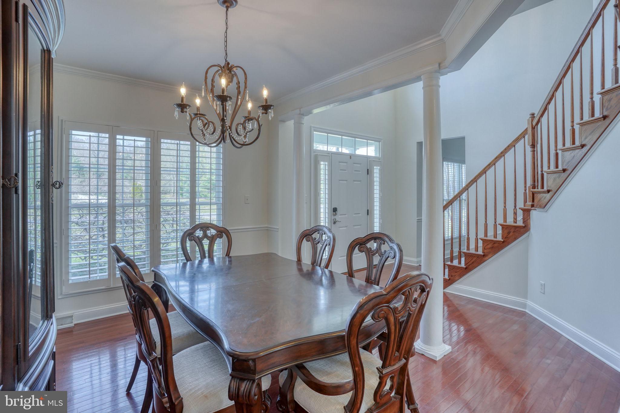 210 Grapevine Way Milford, DE 19963 - Photo 25 of 61 a dining room with wooden floor a chandelier a wooden table and chairs