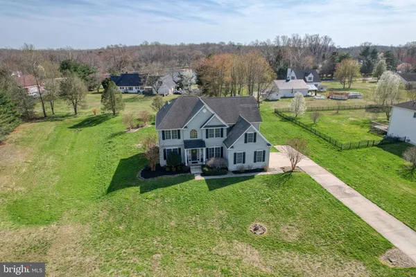 an aerial view of residential houses with outdoor space and trees