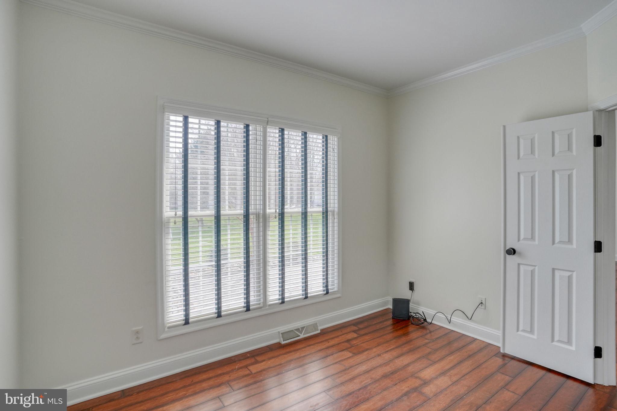 210 Grapevine Way Milford, DE 19963 - Photo 32 of 61 a view of an empty room with wooden floor and a window
