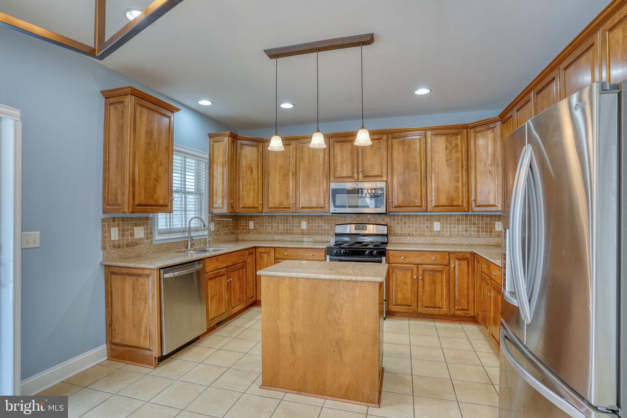 210 Grapevine Way Milford, DE 19963 - Photo 37 of 61 a kitchen with stainless steel appliances granite countertop a refrigerator a stove top oven a sink and dishwasher