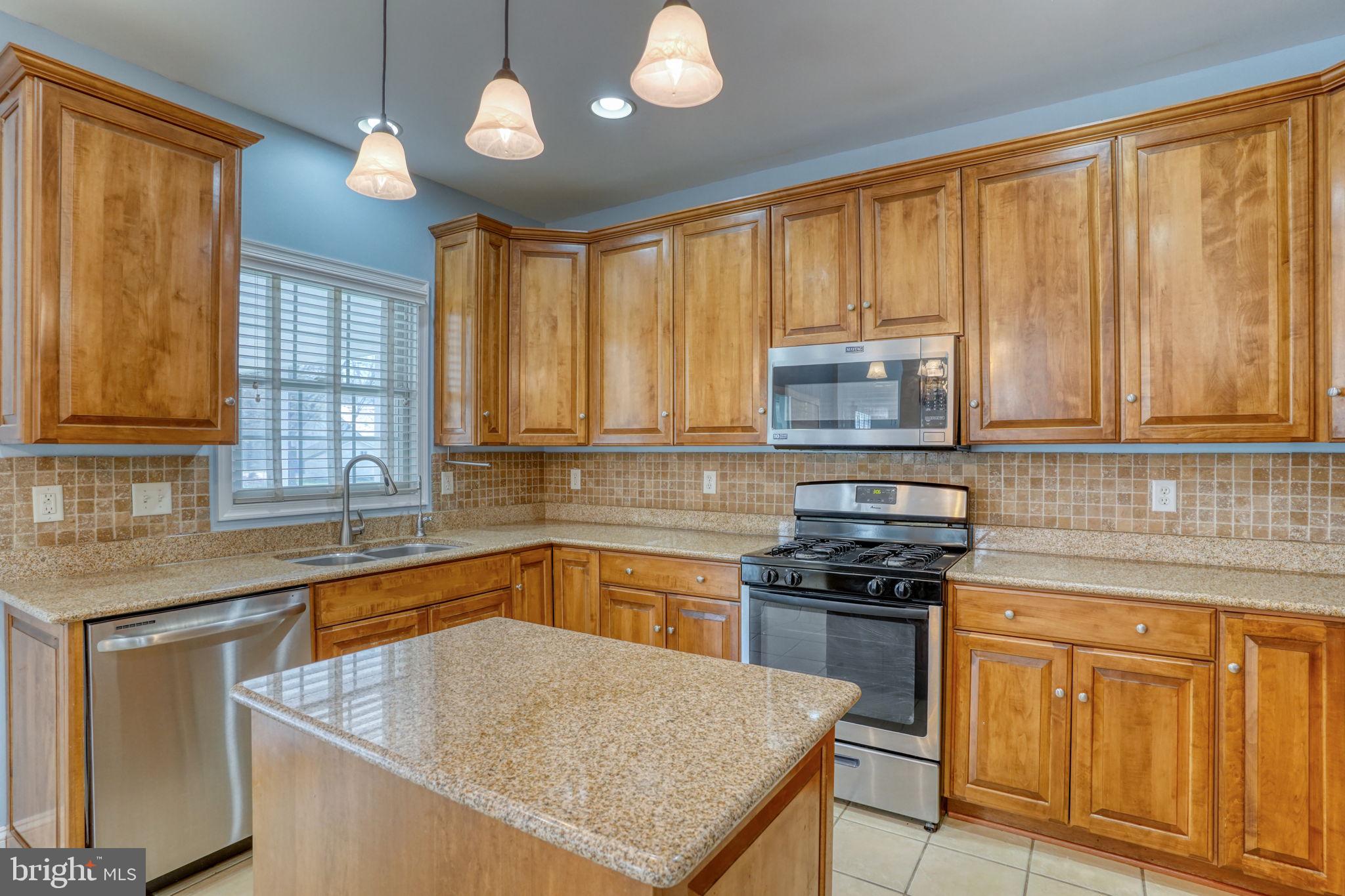 210 Grapevine Way Milford, DE 19963 - Photo 39 of 61 a kitchen with granite countertop stainless steel appliances a stove sink and cabinets
