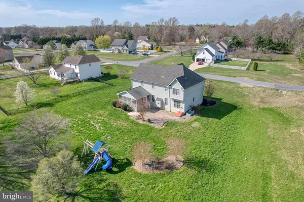 an aerial view of residential houses with outdoor space and trees