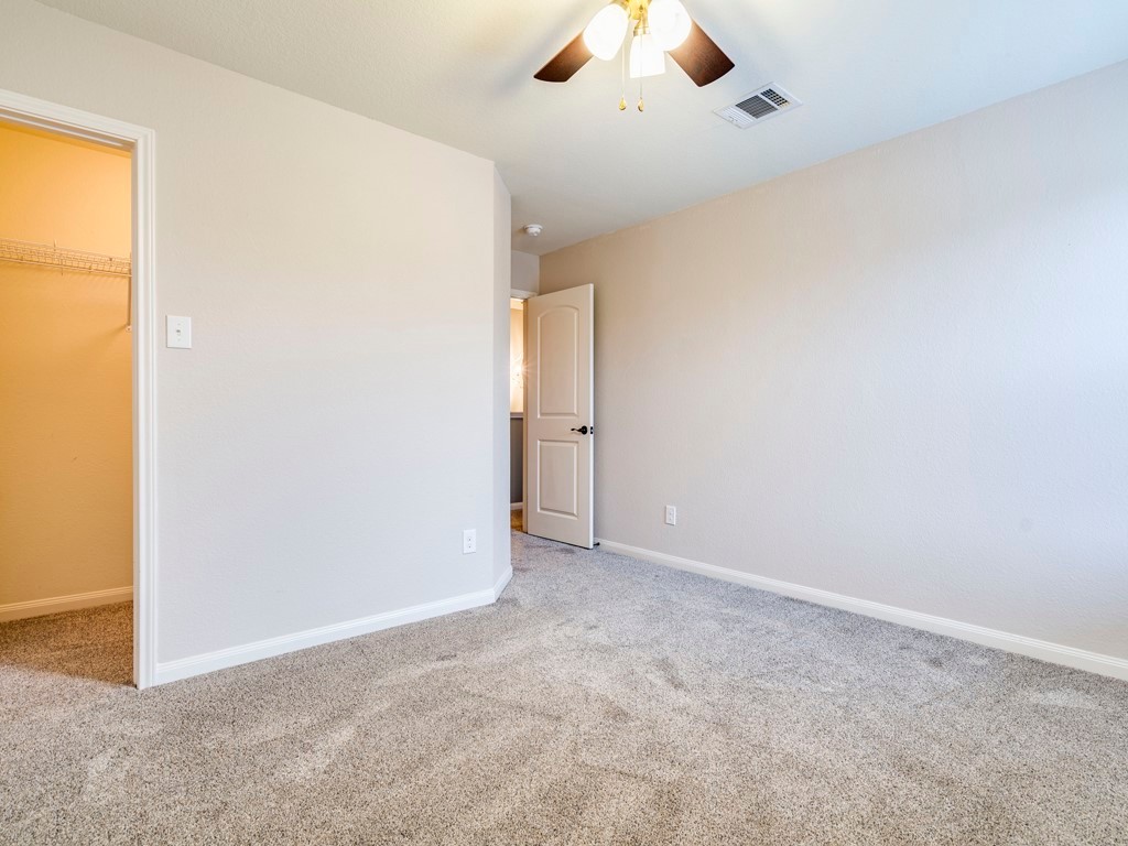 216 Isabel Lane Kyle, TX 78640 - Photo 18 of 27 an empty room with a window and a ceiling fan