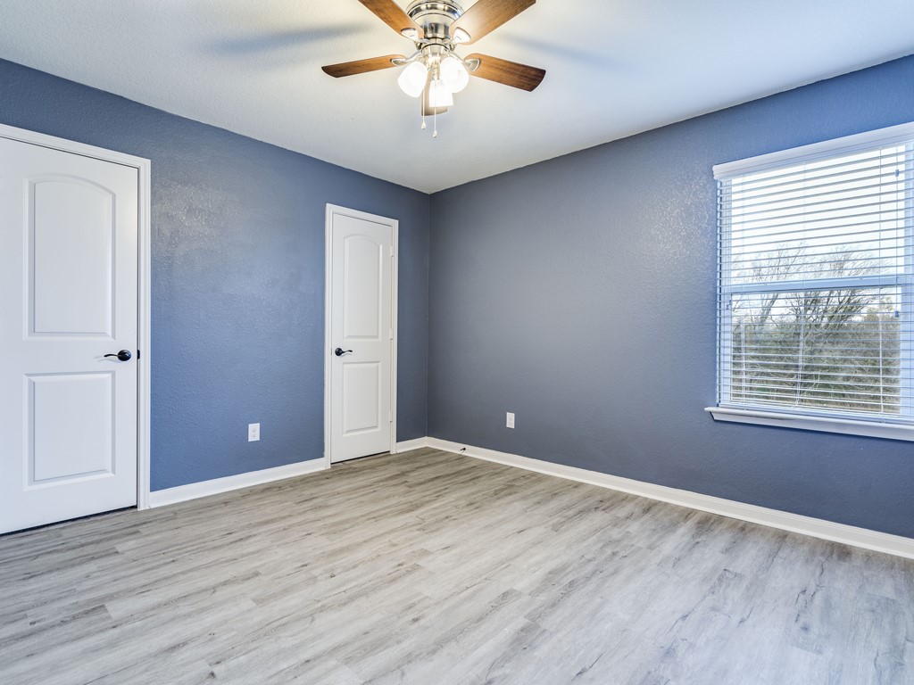 216 Isabel Lane Kyle, TX 78640 - Photo 19 of 27 a view of an empty room with wooden floor and a window