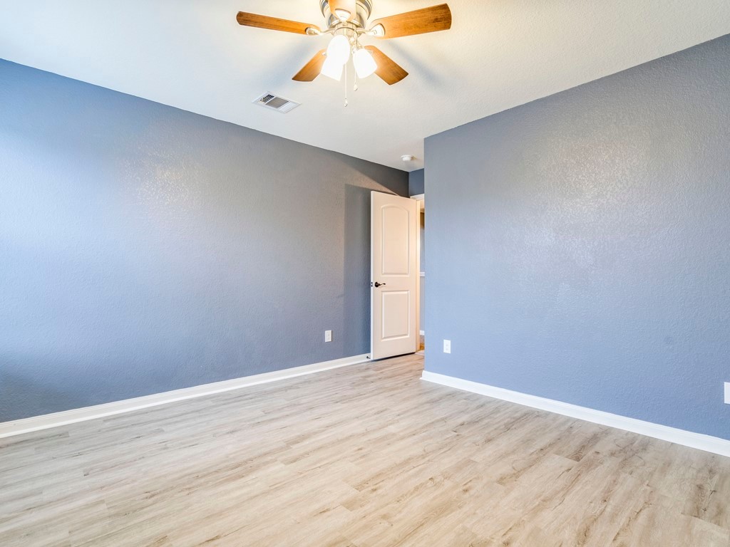 216 Isabel Lane Kyle, TX 78640 - Photo 20 of 27 a view of an empty room with window and wooden floor