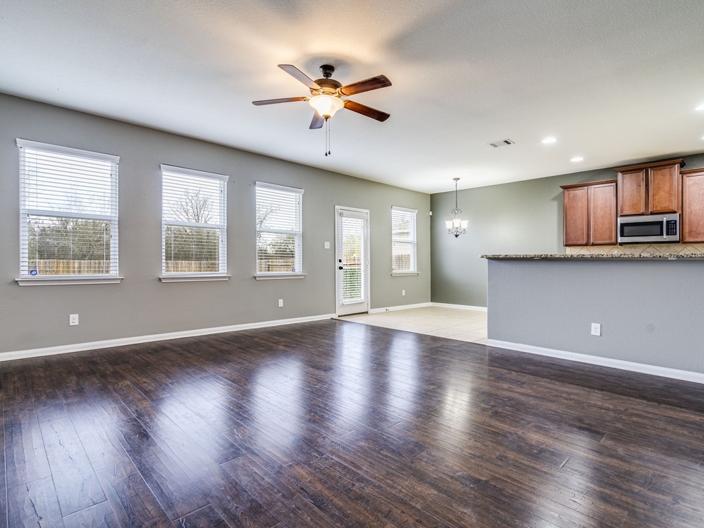 216 Isabel Lane Kyle, TX 78640 - Photo 4 of 27 a view of an empty room with a window and wooden floor