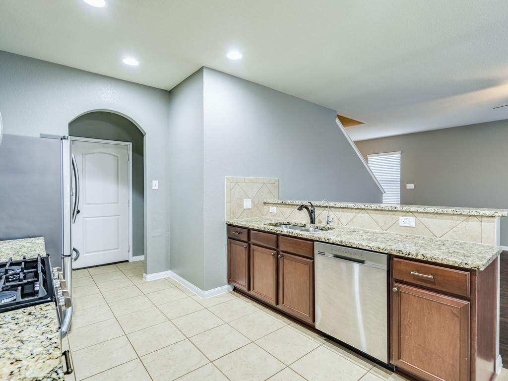 216 Isabel Lane Kyle, TX 78640 - Photo 10 of 27 a kitchen with granite countertop a sink and white cabinets
