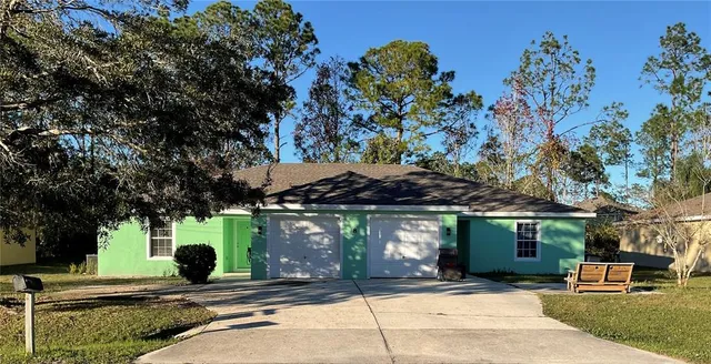 a view of a house with a tree in front of it