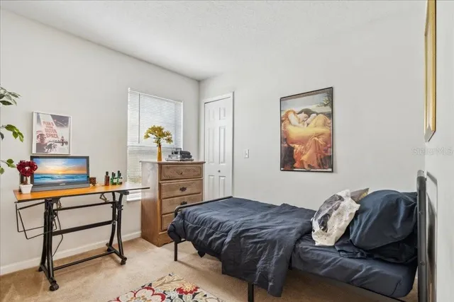 a bedroom with a bed and a flat tv screen on dresser
