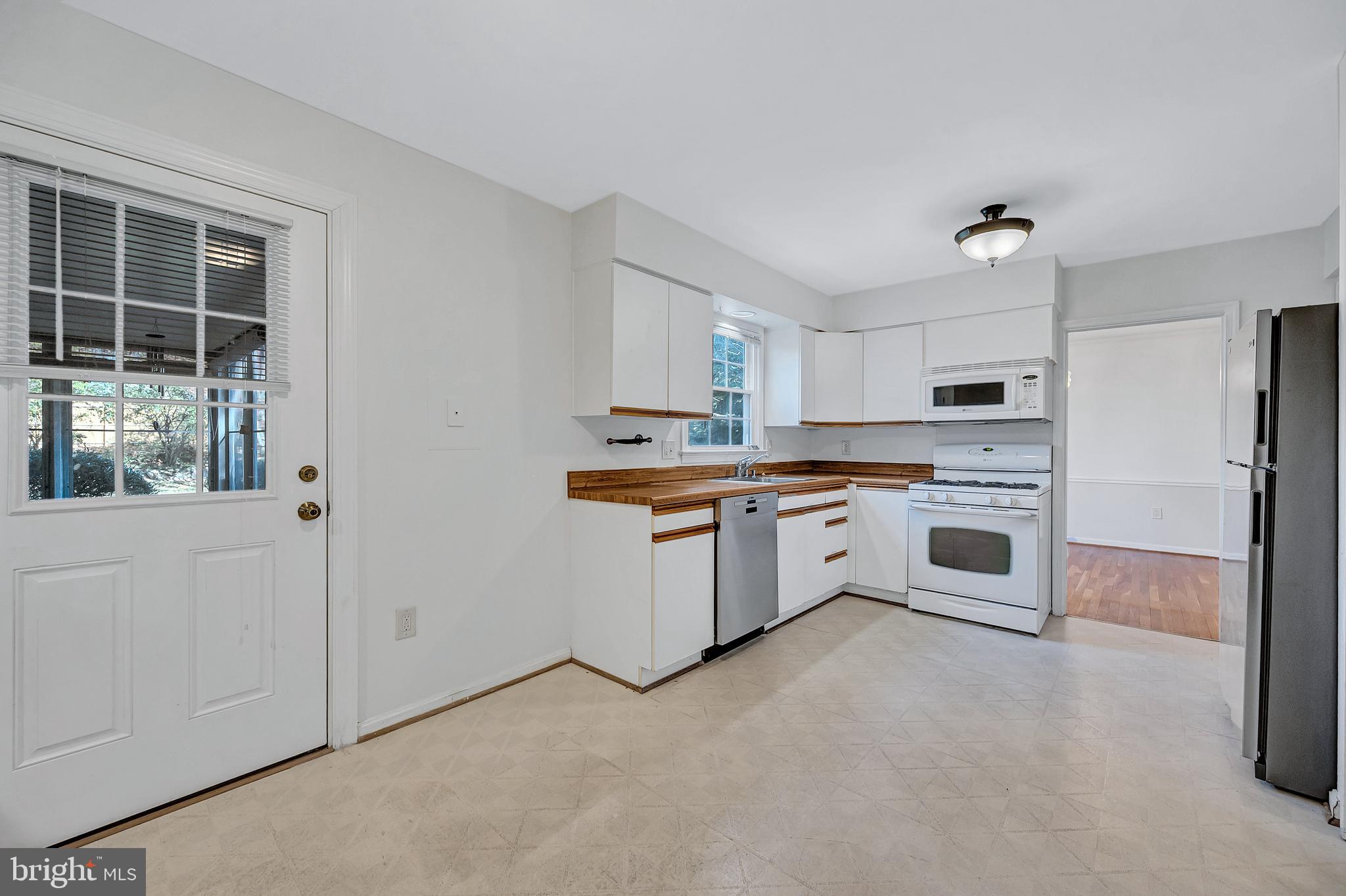 8617 Atwell Road Potomac, MD 20854 - Photo 11 of 39 a kitchen with white cabinets and white appliances