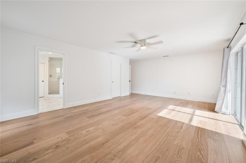 508 Devils Lane Naples, FL 34103 - Photo 18 of 35 wooden floor in an empty room with a window