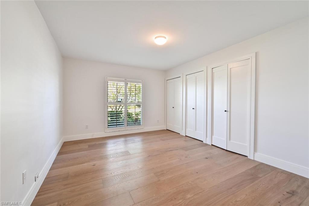 508 Devils Lane Naples, FL 34103 - Photo 21 of 35 a view of an empty room with wooden floor and a window