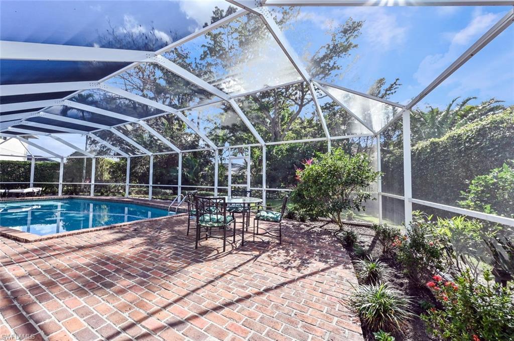 508 Devils Lane Naples, FL 34103 - Photo 30 of 35 a view of a patio with table and chairs potted plants with wooden floor and fence