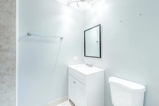 a spacious bathroom with a toilet sink and mirror