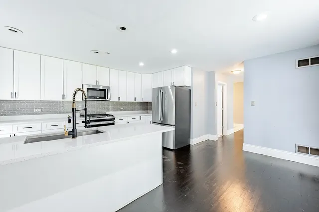 a kitchen with stainless steel appliances a refrigerator sink and cabinets