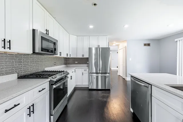 a kitchen with a sink a stove a refrigerator and cabinets