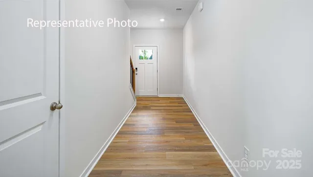 a view of a hallway with wooden floor