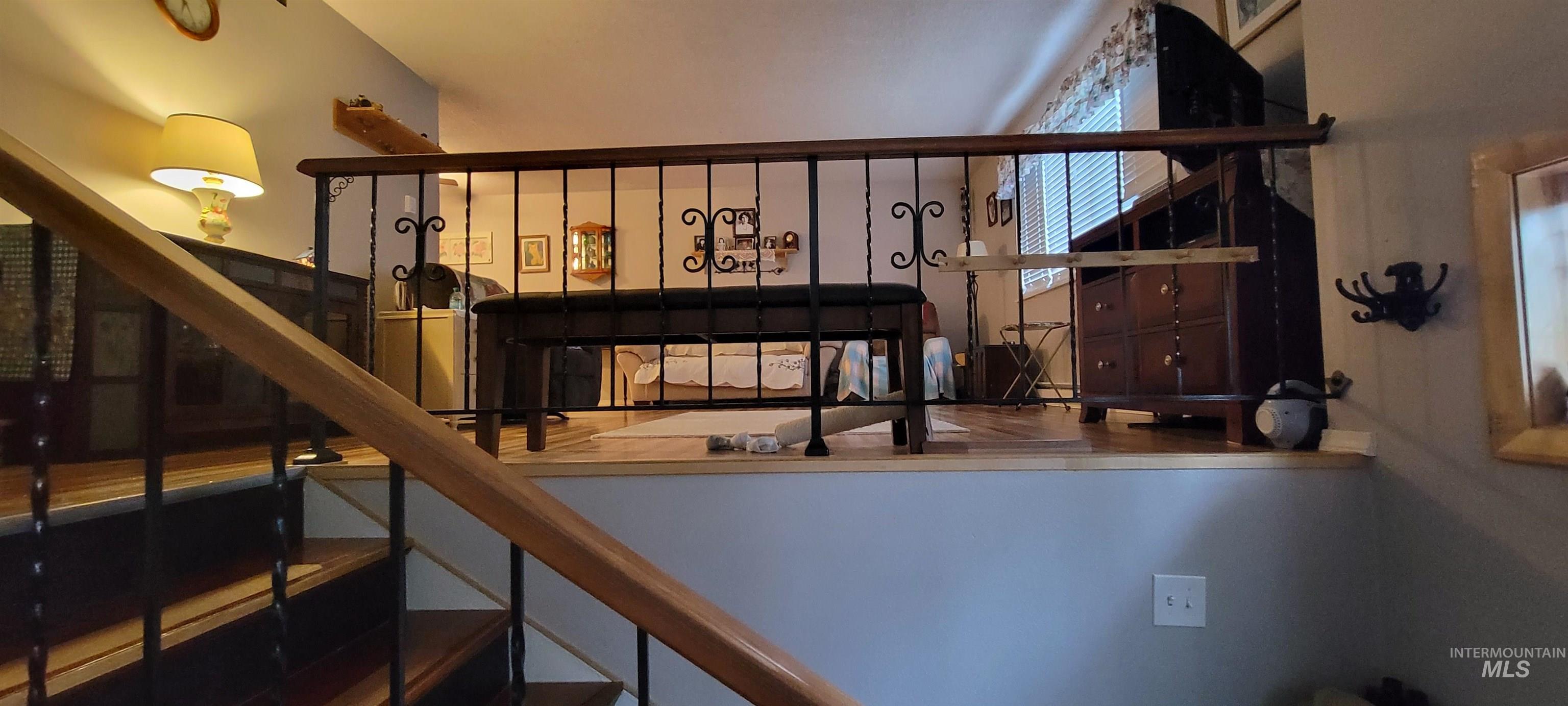 818 Baker Road Kamiah, ID 83536 - Photo 28 of 31 Staircase with wood-finish treads and black risers, featuring a black wrought iron railing with a wood-finish handrail