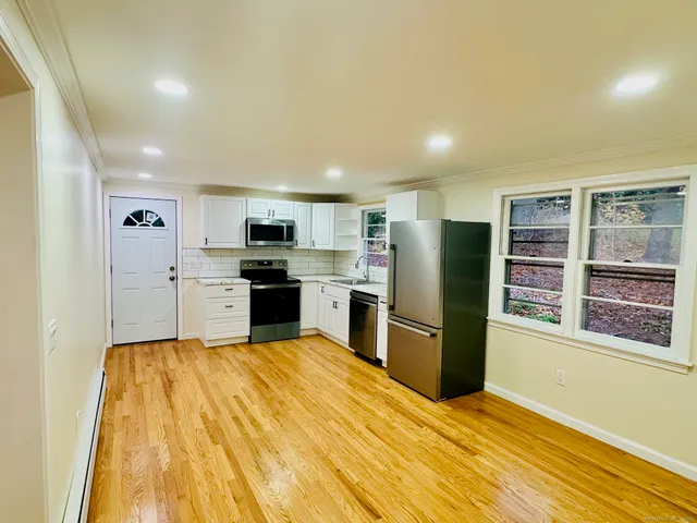 a kitchen with stainless steel appliances granite countertop a refrigerator and a stove top oven