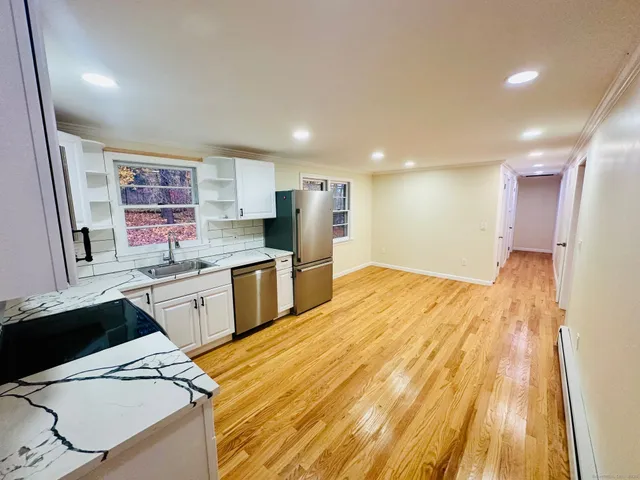 a large kitchen with a lot of counter space and a wooden floor