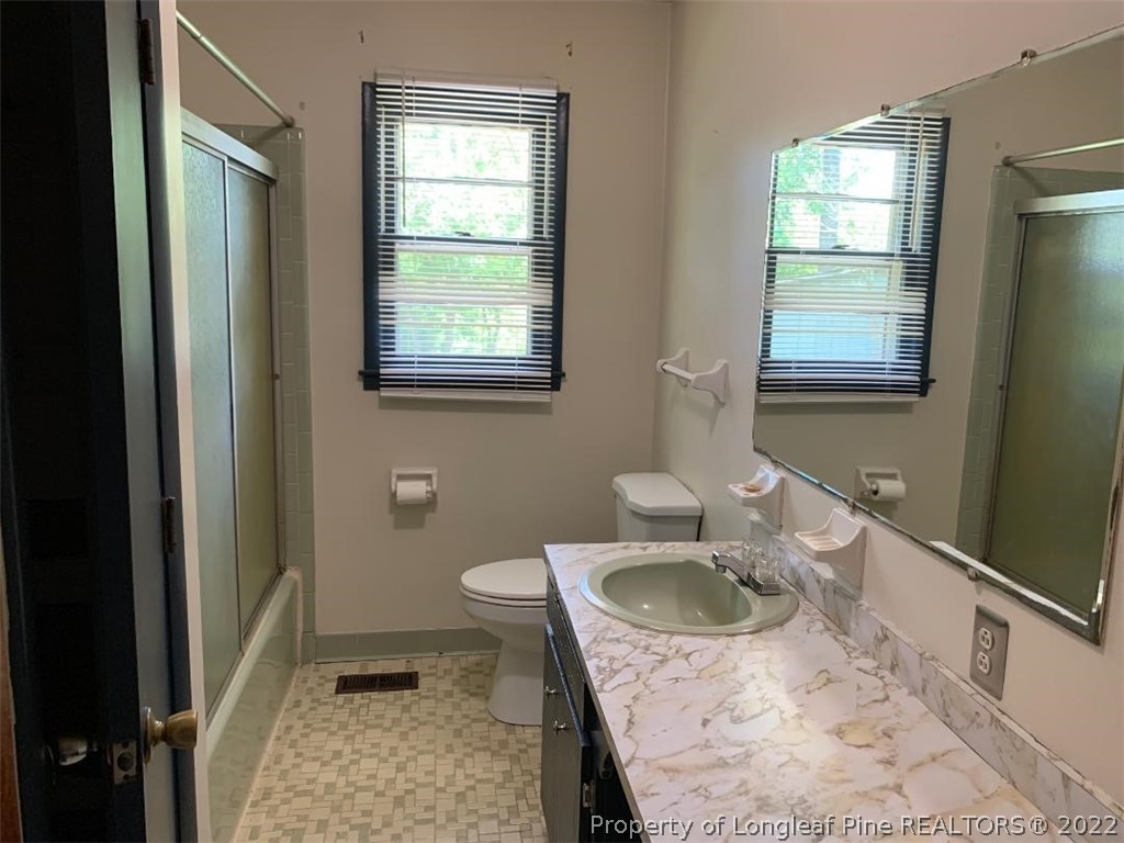 2681 Raynham Road Fairmont, NC 28340 - Photo 10 of 10 a bathroom with a sink a toilet and a window