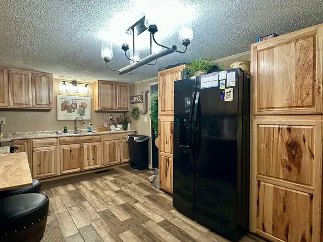 a kitchen with granite countertop stainless steel appliances a refrigerator cabinets and a sink