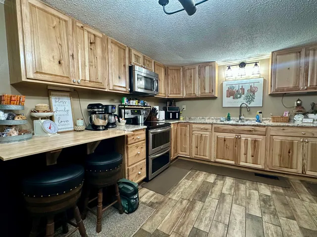 a kitchen with granite countertop a sink cabinets stainless steel appliances and a window