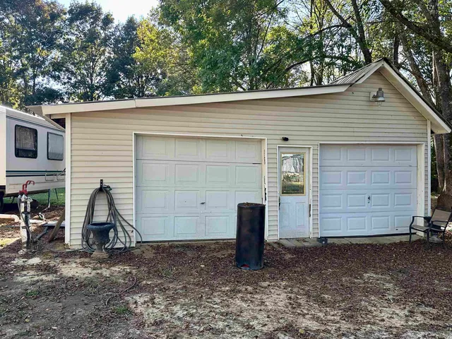 a white house that has a small yard and a large tree