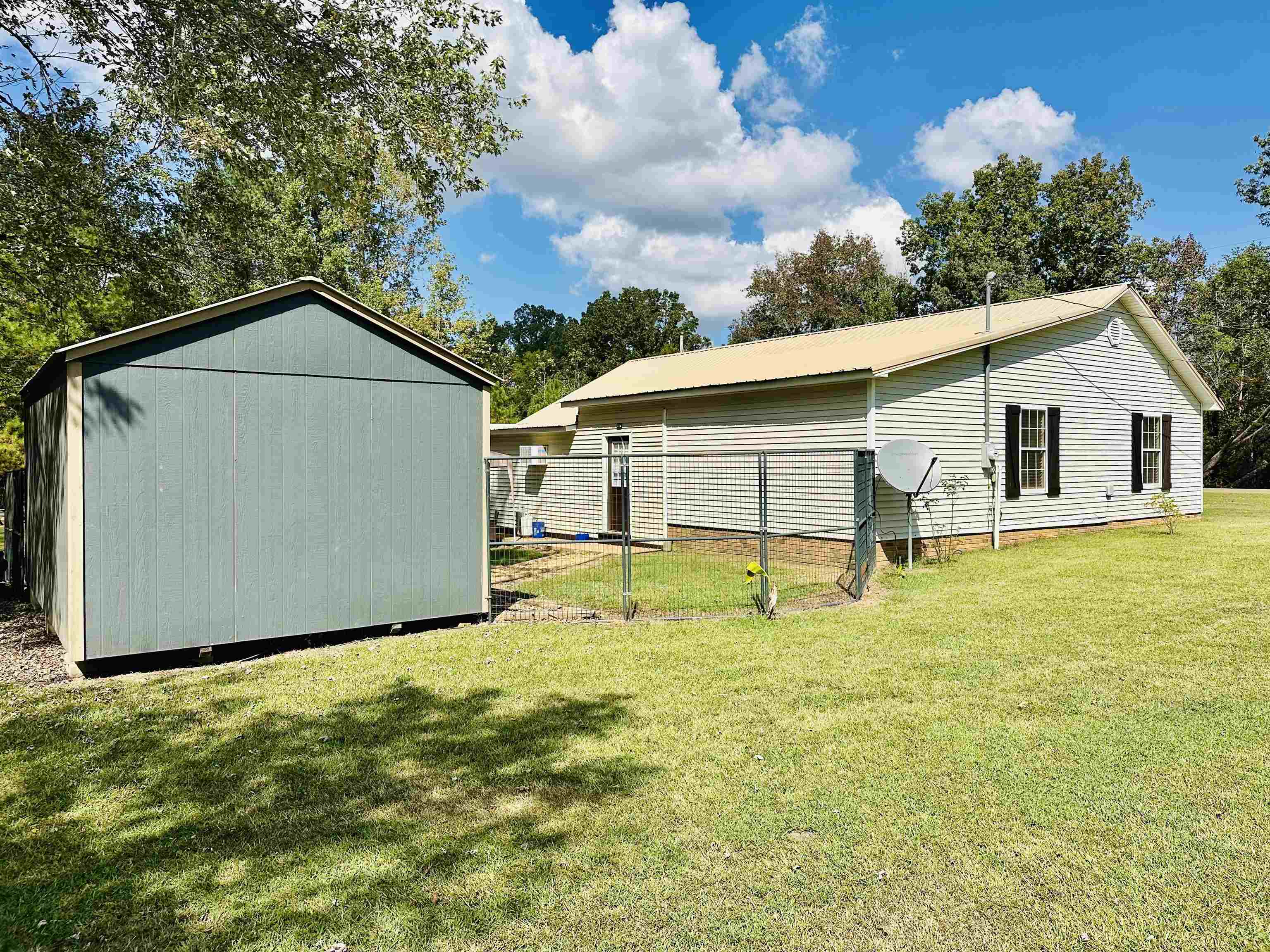 4769 Pleasant Site Road Selmer, TN 38375 - Photo 25 of 28 a white house that has a small yard and a large tree