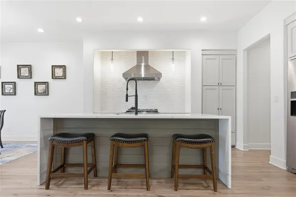 a kitchen with stainless steel appliances granite countertop a sink and cabinets with wooden floor