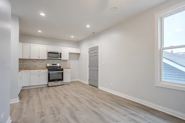 a kitchen with stainless steel appliances a refrigerator and a stove top oven