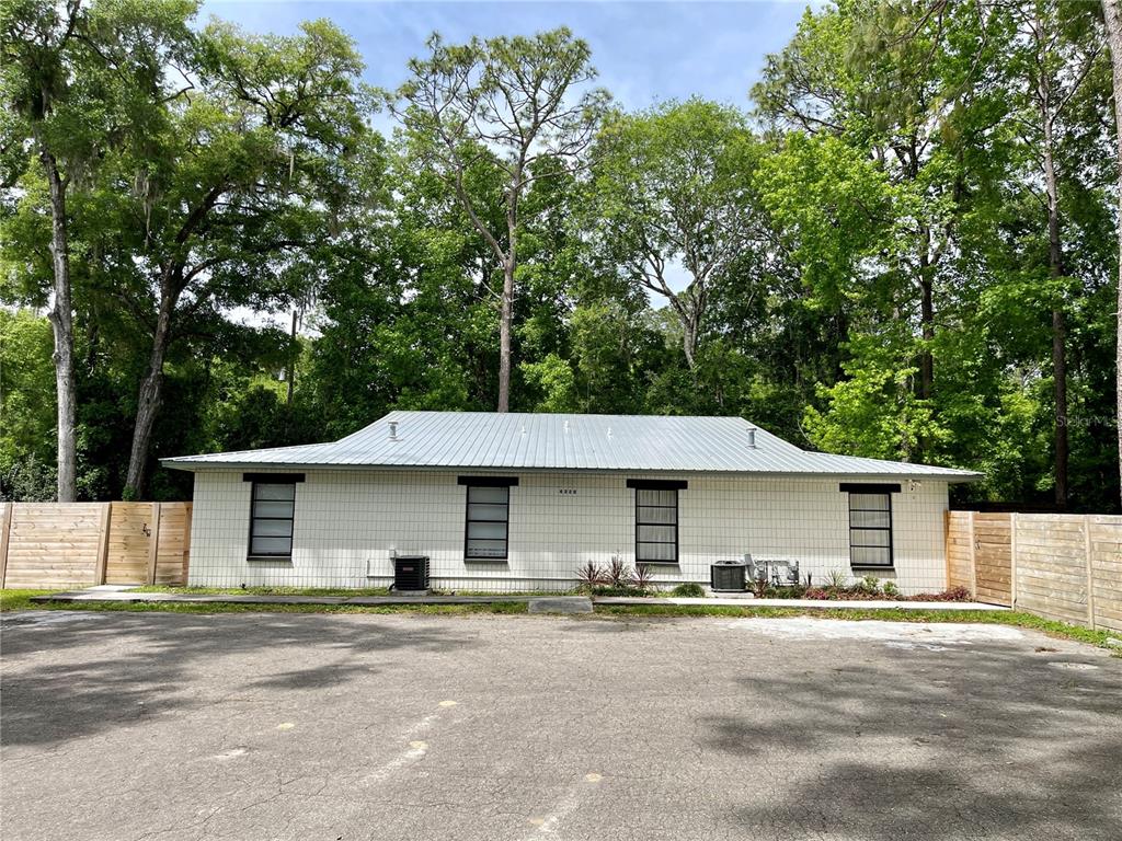 4320 Southwest 74th Terrace, Unit 3 Gainesville, FL 32608 - Photo 1 of 15 a view of a yard in front of a house with large tree