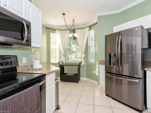 a kitchen with granite countertop a refrigerator and a stove top oven